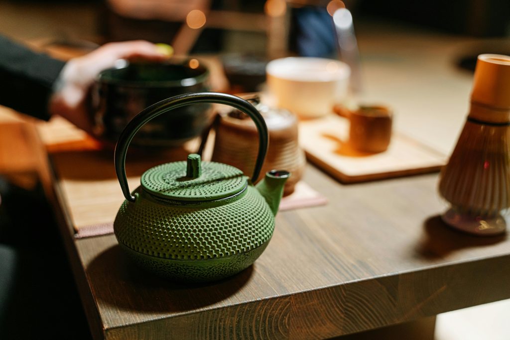 A green teapot on a table