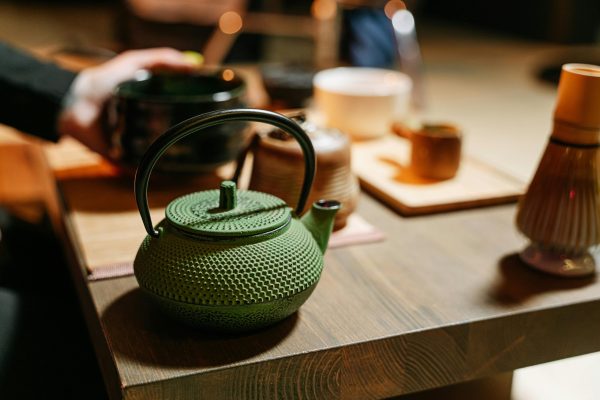 A green teapot on a table